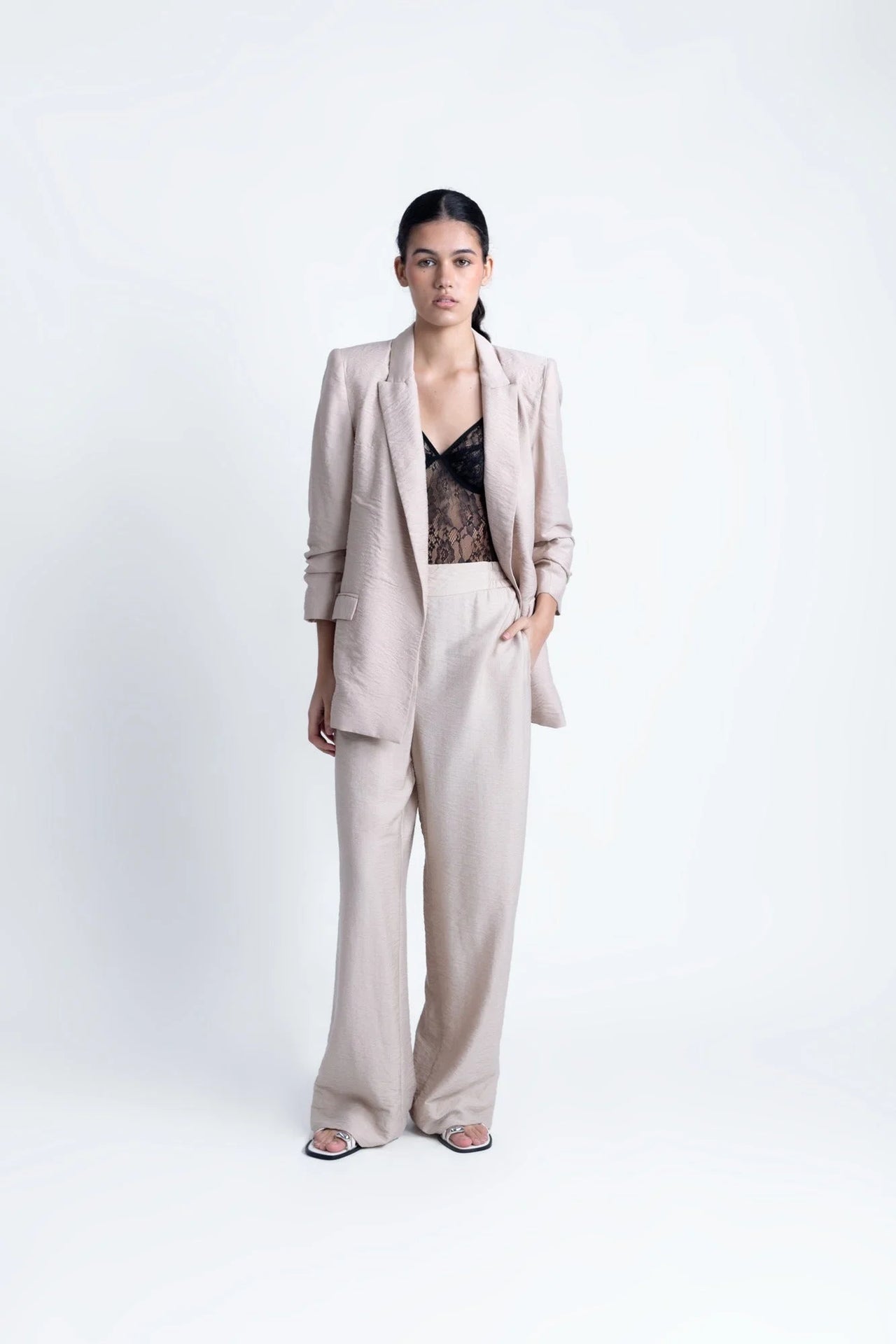 Alt texte d’une femme portant un ensemble pantalon fluide beige et blazer assorti