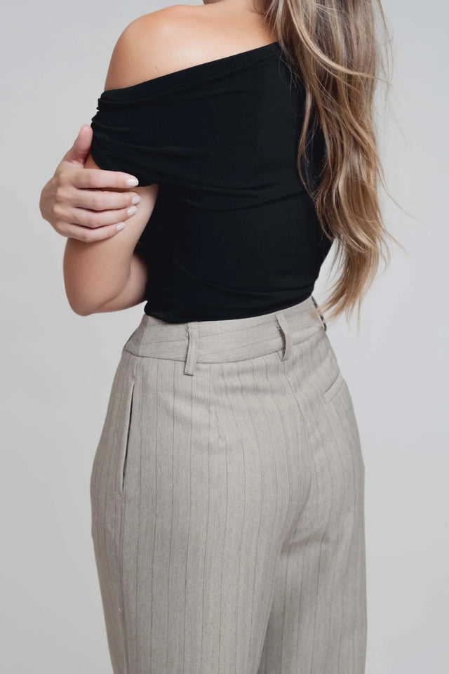 Détails du dos d'un haut noir porté avec un pantalon fluide à rayures, parfaite illustration du pantalon fluide femme taille haute.