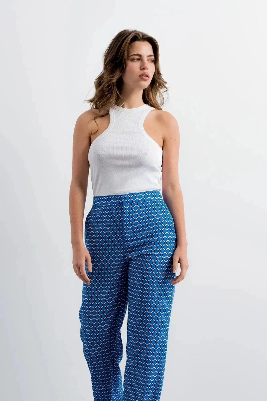 Femme en pantalon imprimé taille haute à jambe large et haut blanc, mettant l'accent sur le pantalon motif femme.