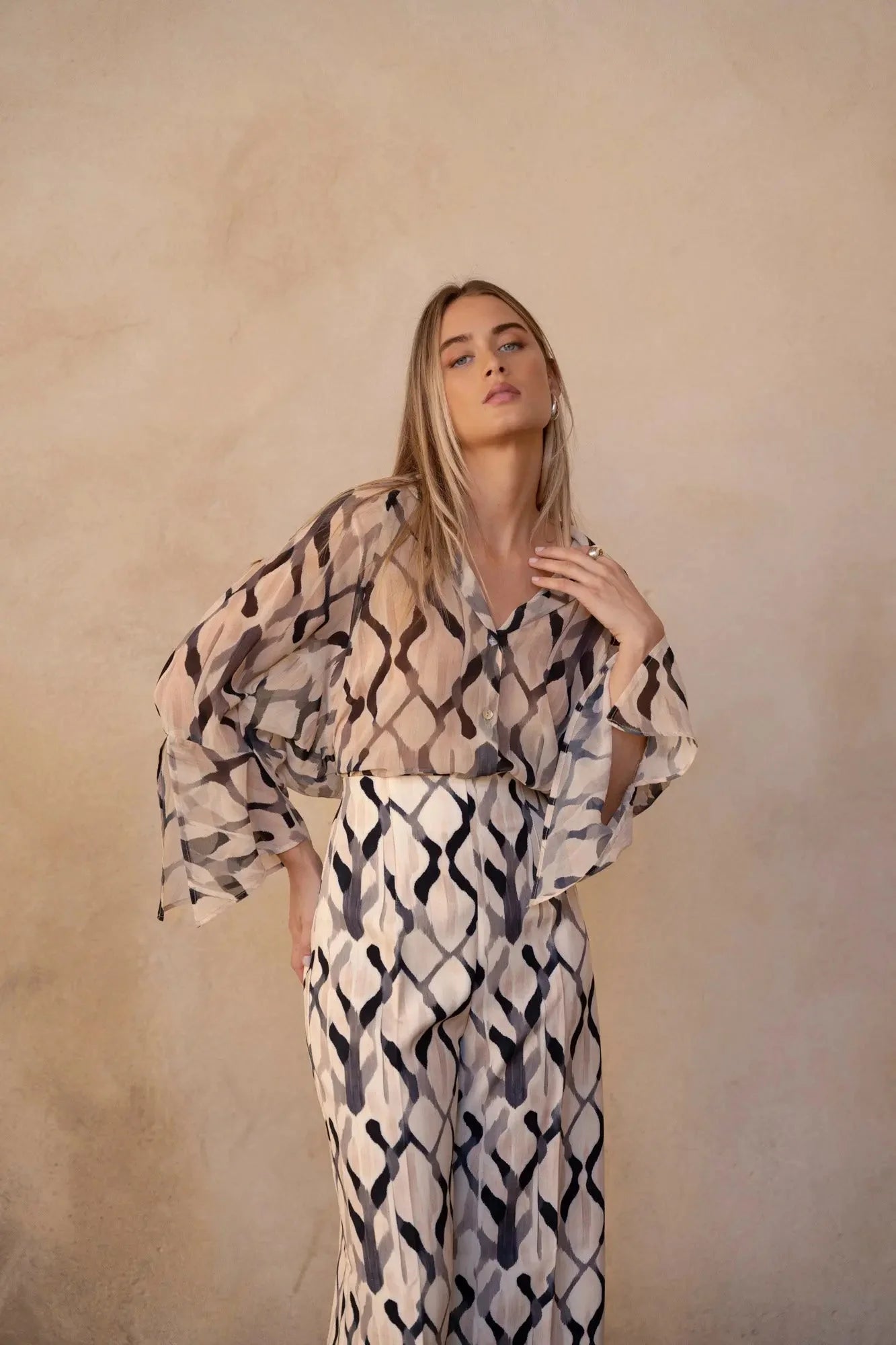 Femme portant un pantalon imprimée culotte palazzo avec blouse fluide à manches bell