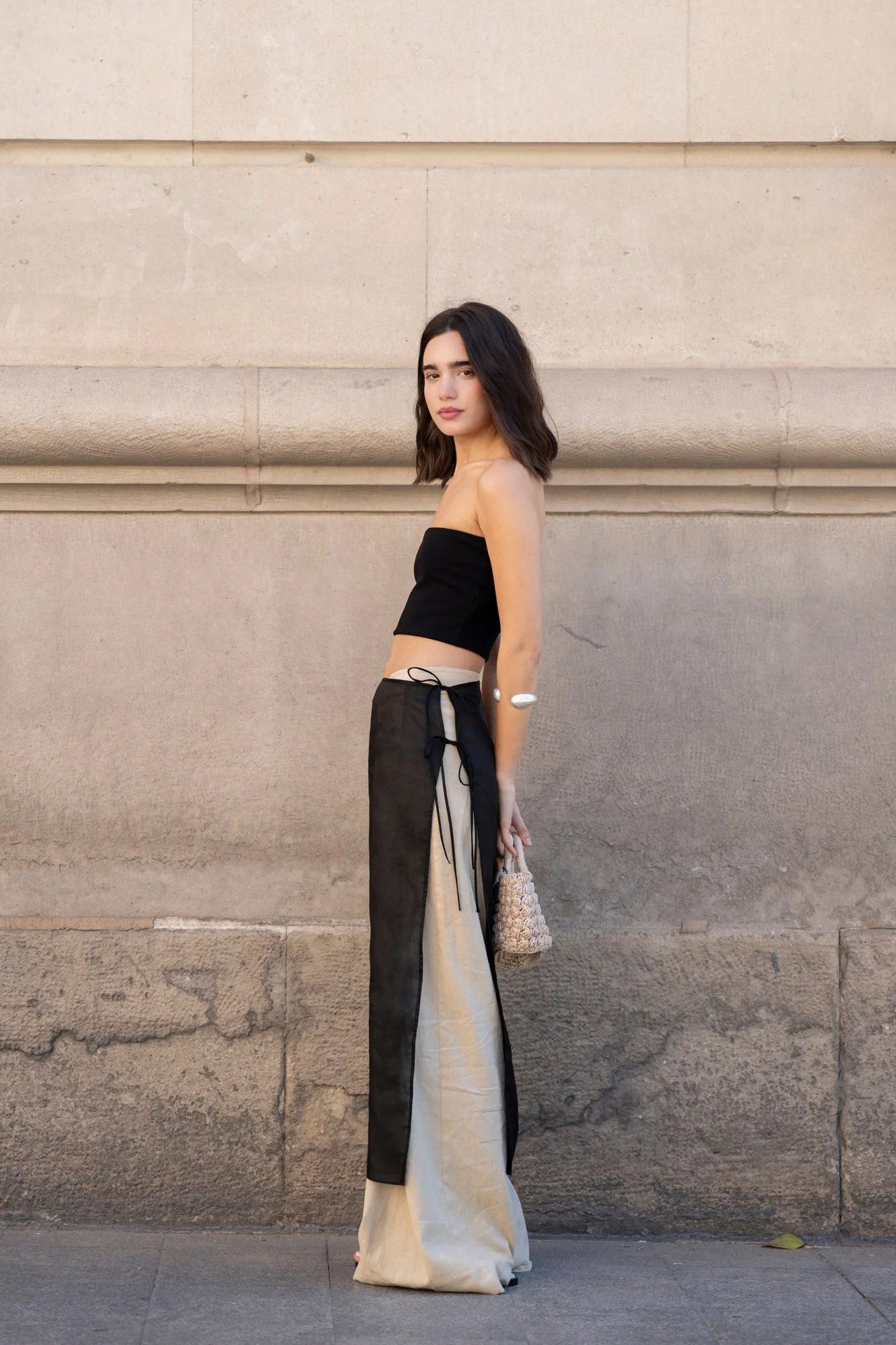 Femme portant un pantalon large en lin beige avec coupe fluide et top noir