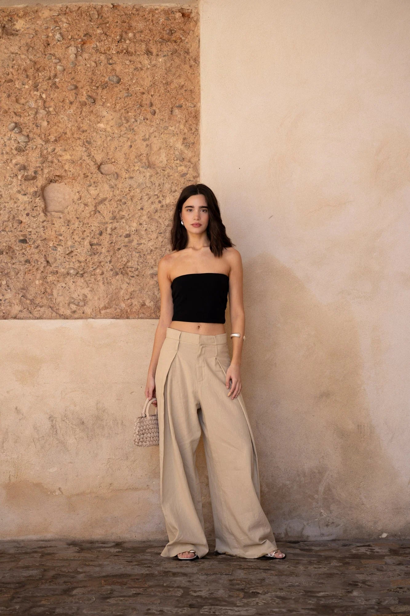Femme portant un pantalon large en lin beige avec coupe fluide et taille structurée