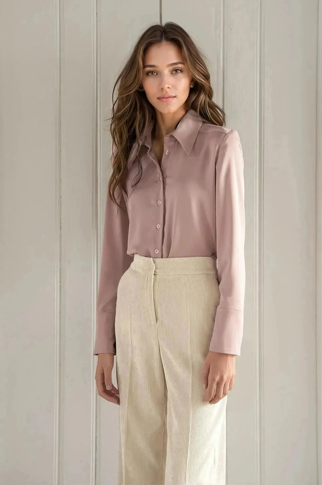 Femme portant un pantalon large en velours côtelé beige et une chemise mauve