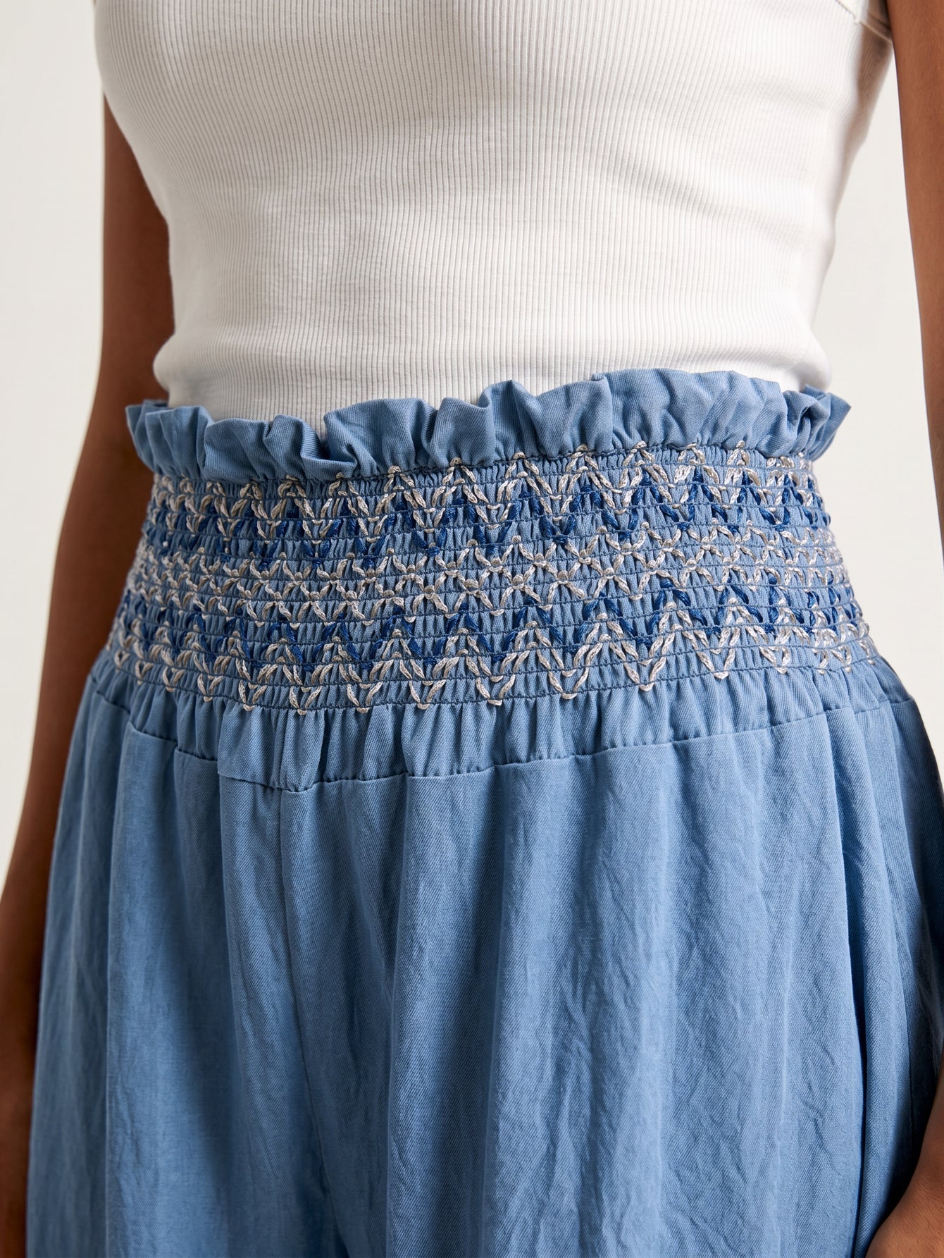 détail taille smockée brodée du pantalon bleu