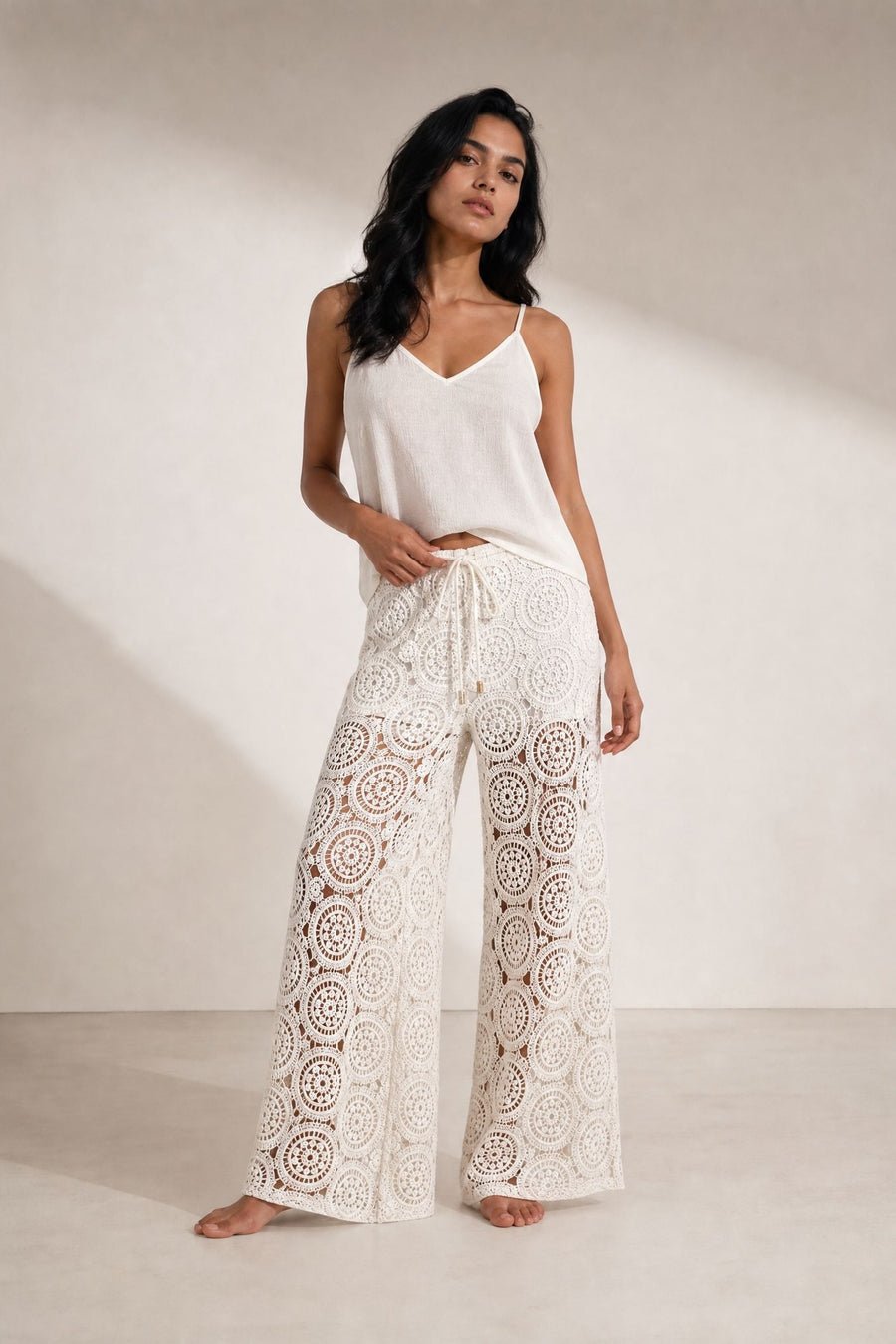 Pantalon palazzo en crochet écru porté de face avec caraco blanc, vue en pied.