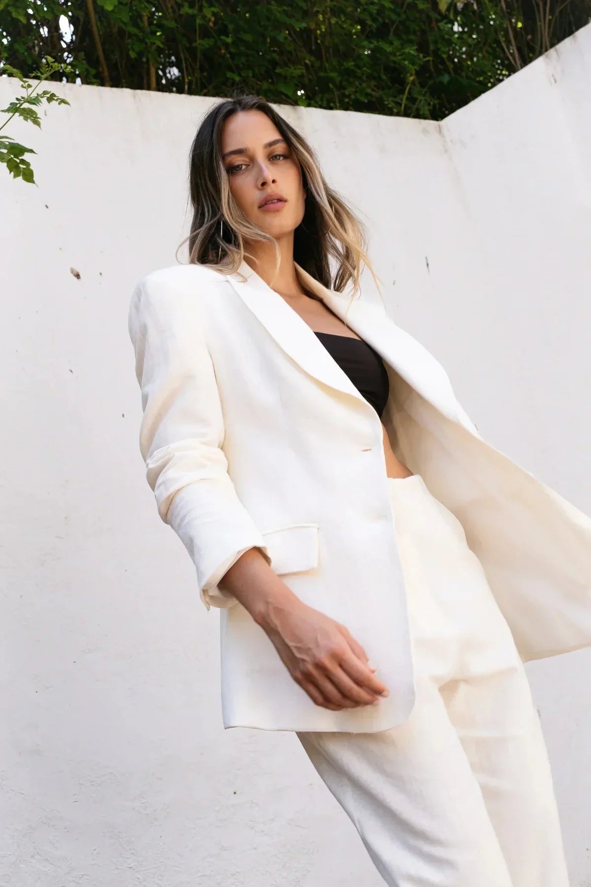Femme portant un pantalon en lin blanc taille haute et blazer blanc pour un look chic