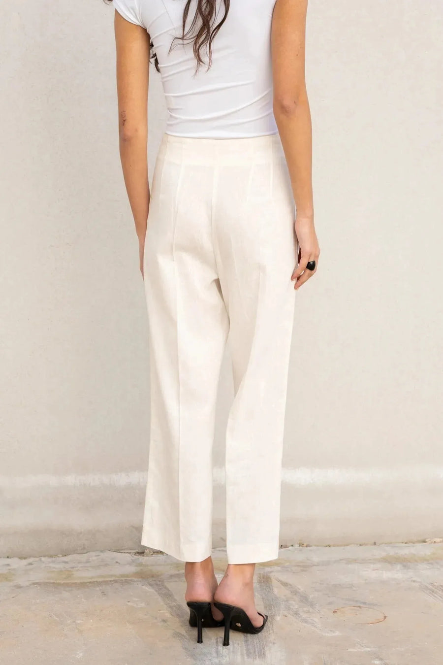 Vue arrière d'une femme en pantalon lin femme taille haute blanc – Chic & Fluide Pour L'Été, mettant en avant le design simple et élégant.