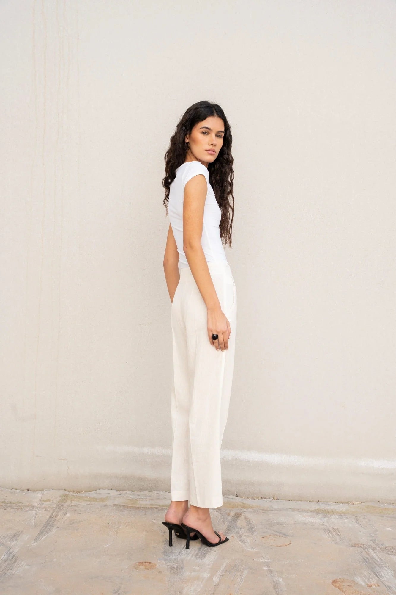 Femme portant pantalon en lin blanc taille haute, lin chic et élégant