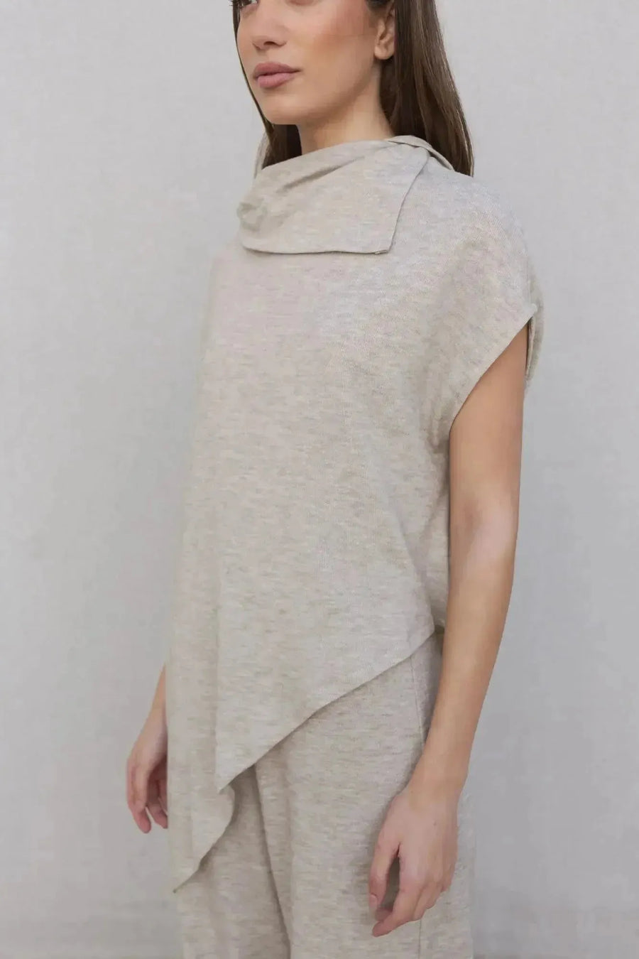 Modèle portant un haut beige asymétrique avec le pantalon tricot femme à jambes larges, alliant confort et style moderne.