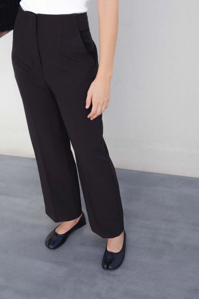 Détail du pantalon à pince femme noir, mettant en valeur sa coupe moderne et élégante, parfaite pour le bureau.