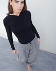 Modèle portant un pantalon ample structuré gris en polyester et viscose, idéal pour un look moderne et confortable.