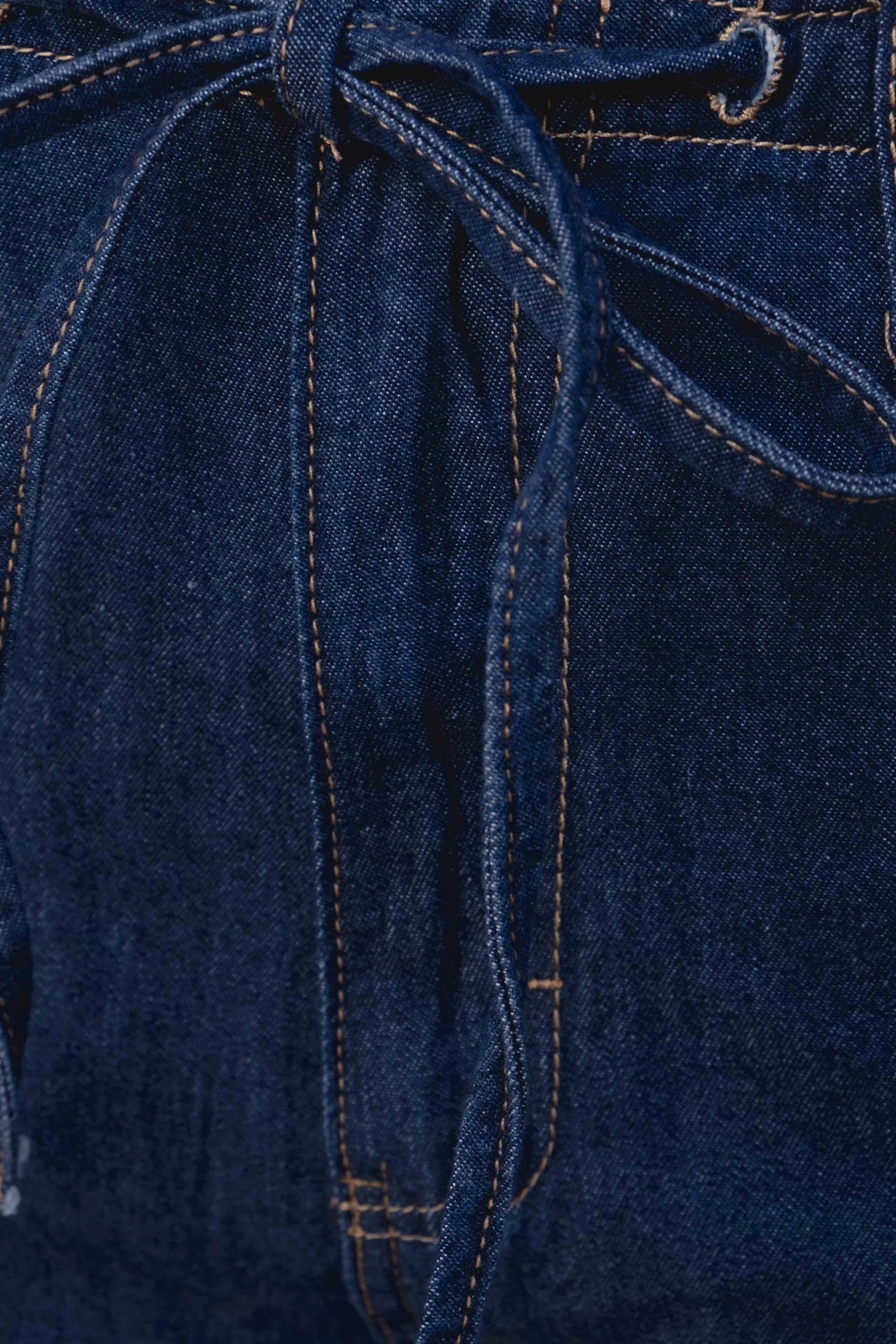Détail du nouage à la taille du pantalon fluide effet denim, soulignant le confort du jean élastique femme.