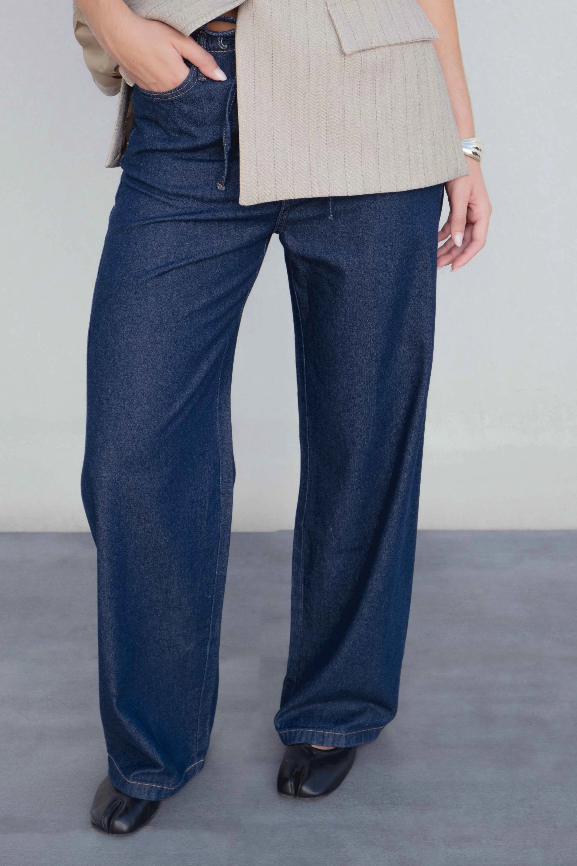 Zoom sur le pantalon fluide effet denim porté par une femme, mettant en valeur le style du jean élastique femme.