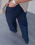Vue arrière du pantalon fluide effet denim sur une femme, illustrant le design du jean élastique femme.