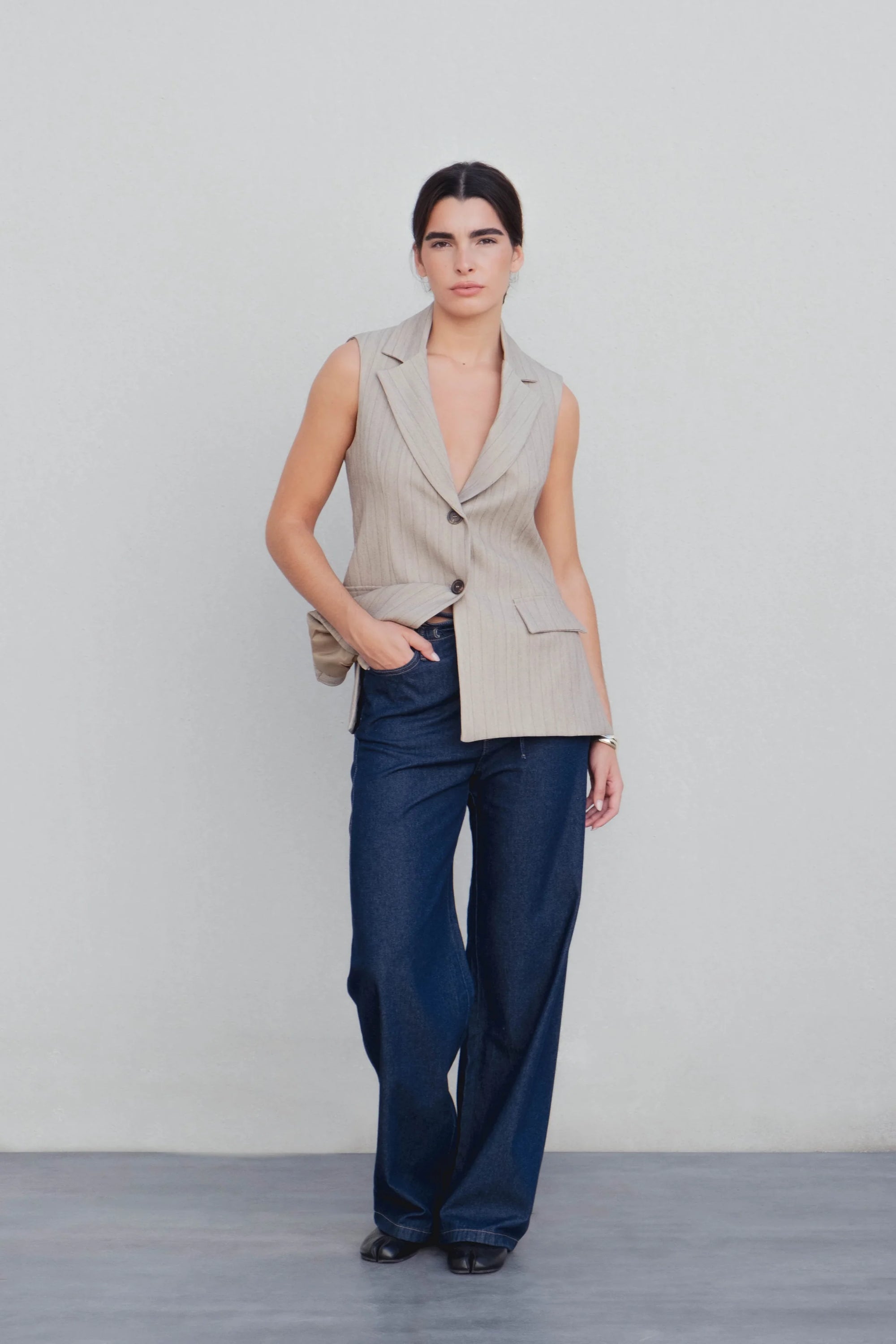 Femme portant un blazer sur un pantalon fluide effet denim, une tenue moderne avec un jean élastique femme.