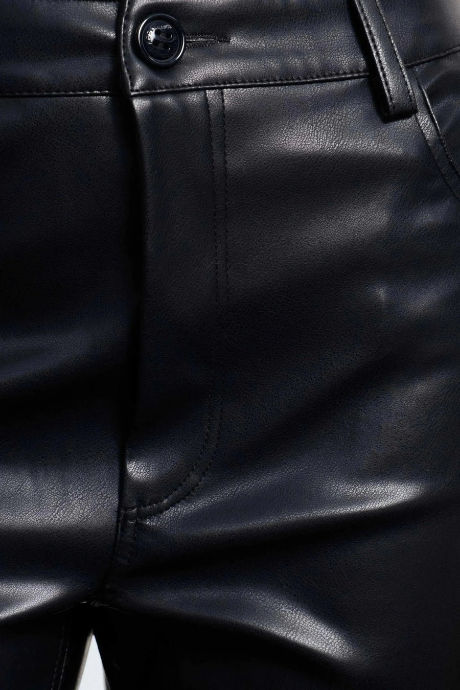 Détail de la texture d'un pantalon imitation cuir femme, mettant en avant la brillance et la finition lisse, idéal pour un look sophistiqué.