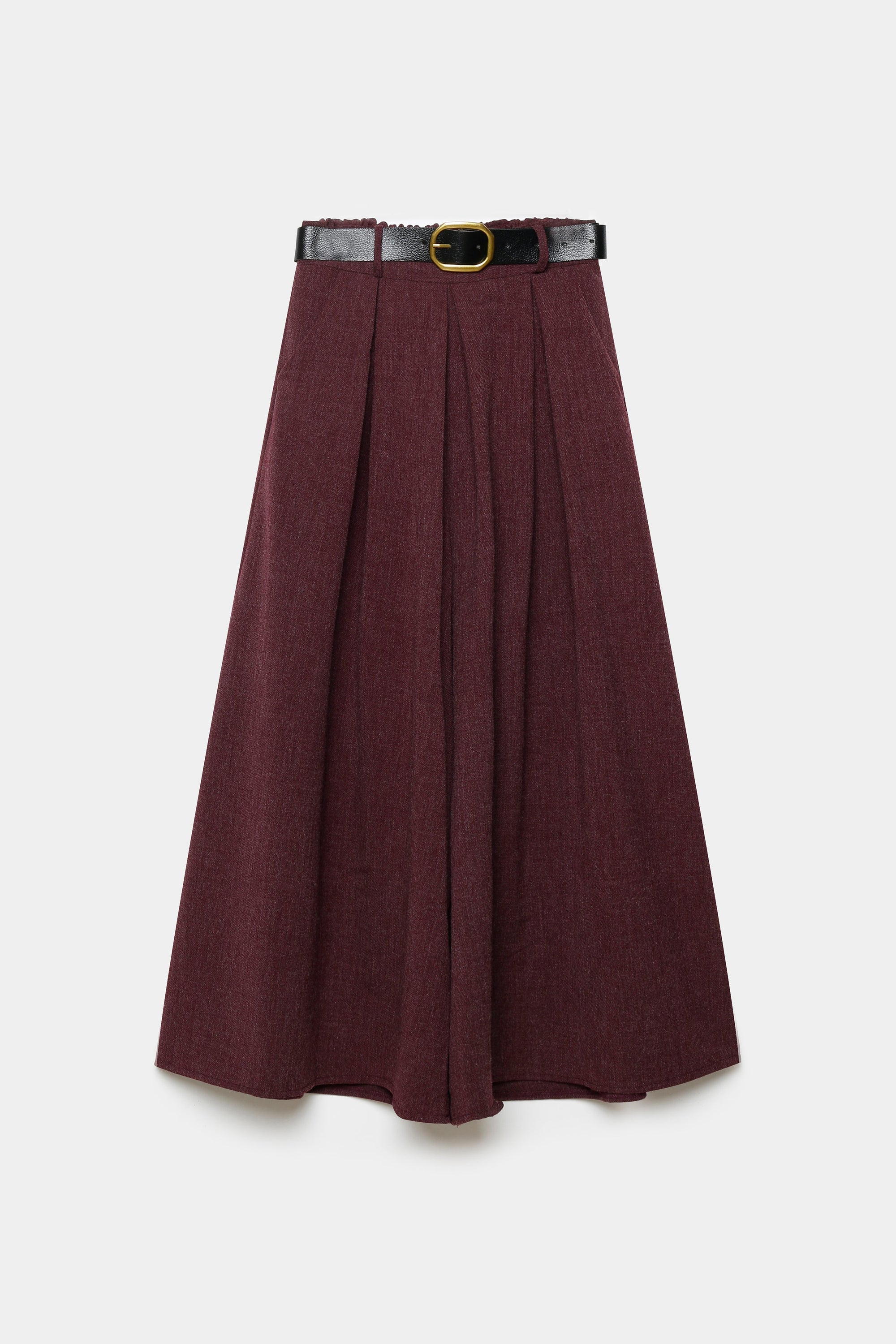 Femme debout ayant un look élégant avec un pantalon large taille haute femme en gris, portant un haut noir.