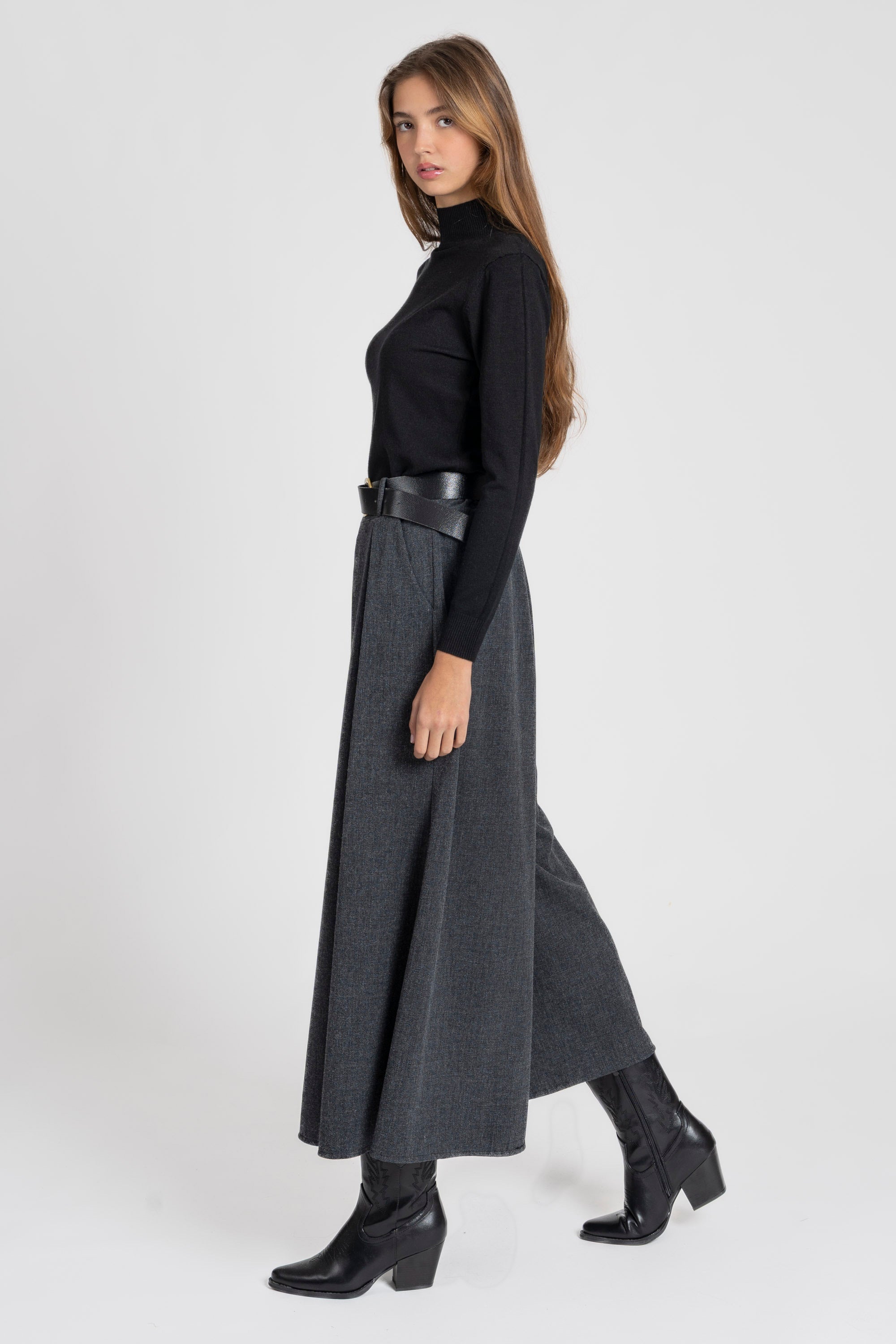 Femme portant un pantalon large taille haute femme gris, mettant en avant une silhouette moderne.
