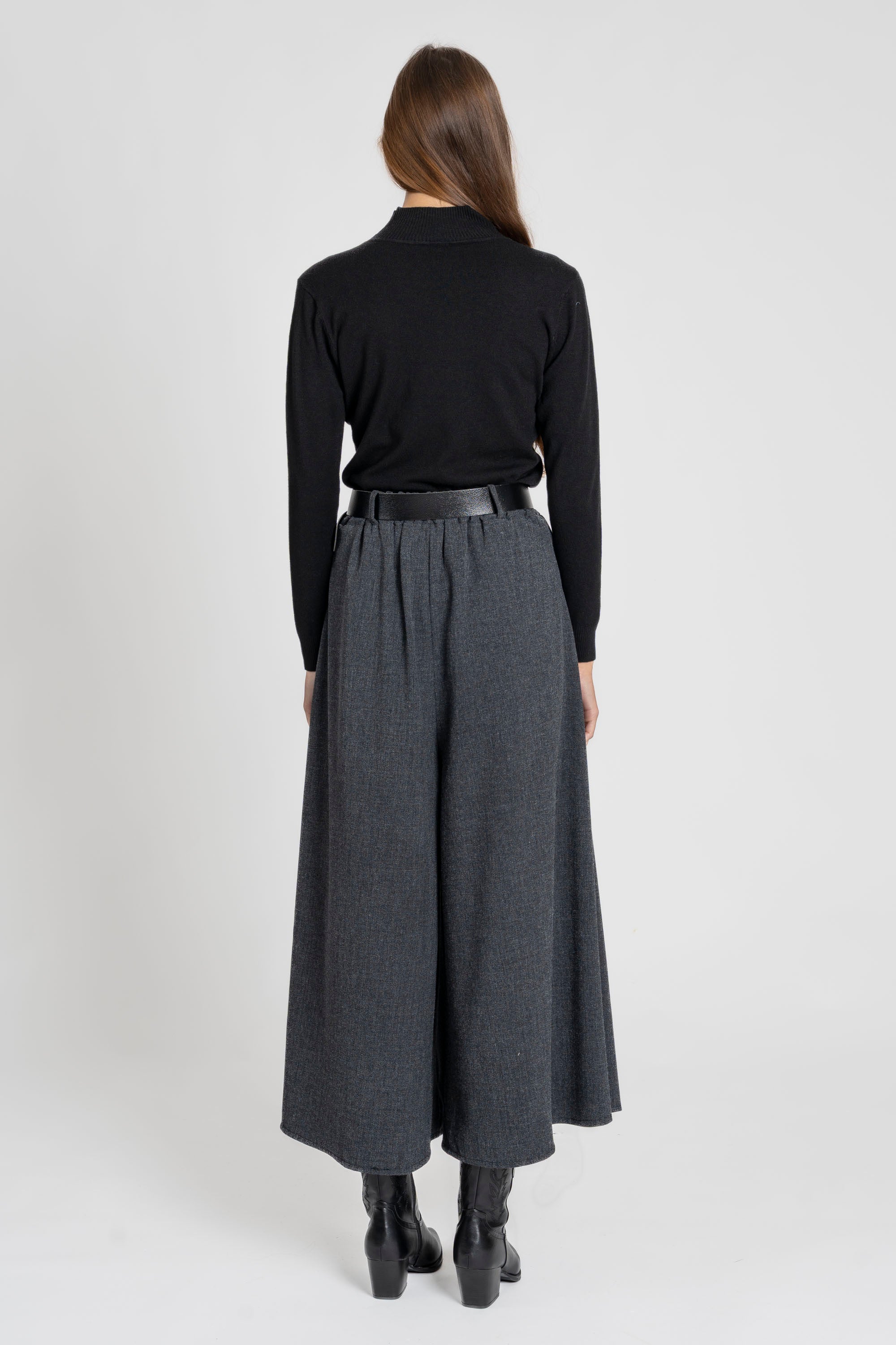 Femme assise en portant un pantalon large taille haute femme, dégageant un look élégant et décontracté.