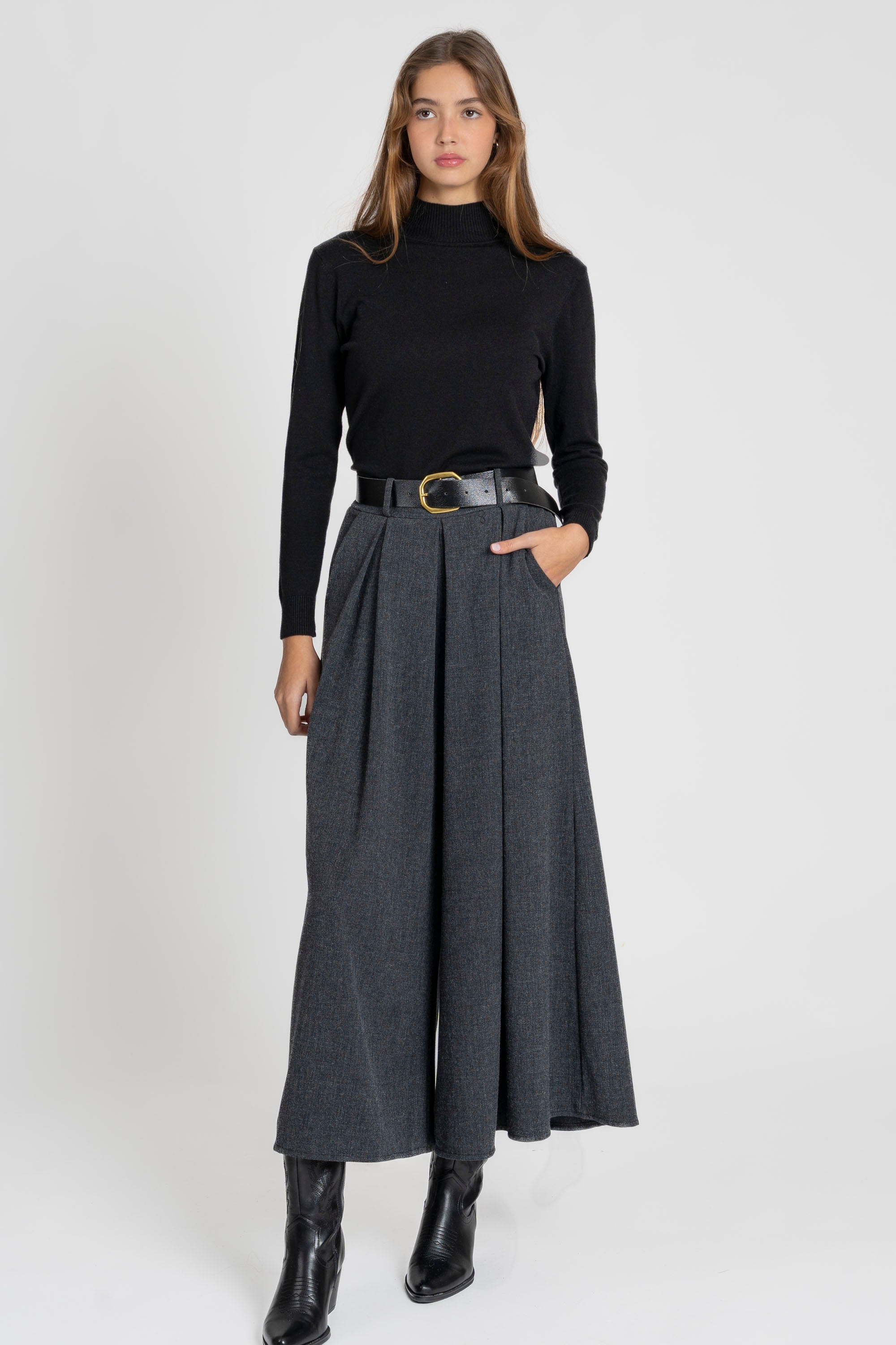 Femme portant un pantalon large taille haute femme dans un style contemporain, associée à un haut noir.