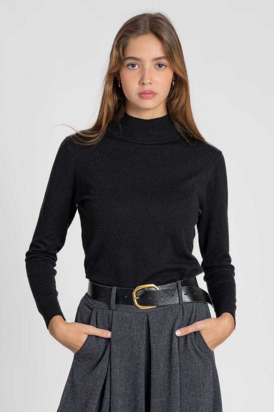 Femme prenant la pose avec un pantalon large taille haute femme gris, mettant en avant la taille haute.
