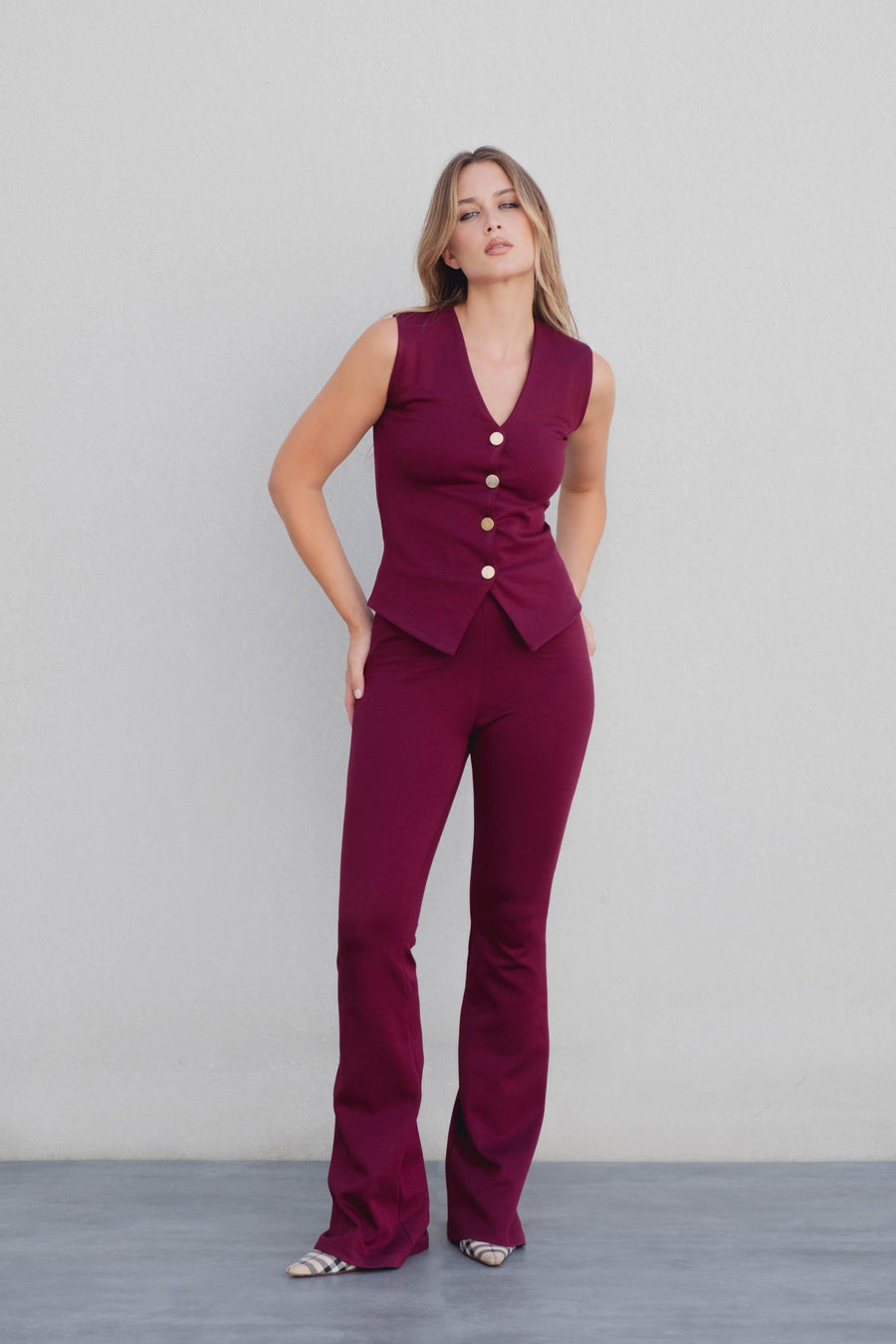 Pantalon en maille texturée taille haute flare bordeaux viscose, présentée par un modèle féminin avec un look élégant, parfait pour le pantalon maille femme.