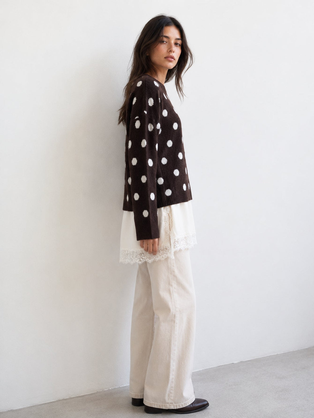 Pull à pois marron avec bas satiné et dentelle, vue de profil portée