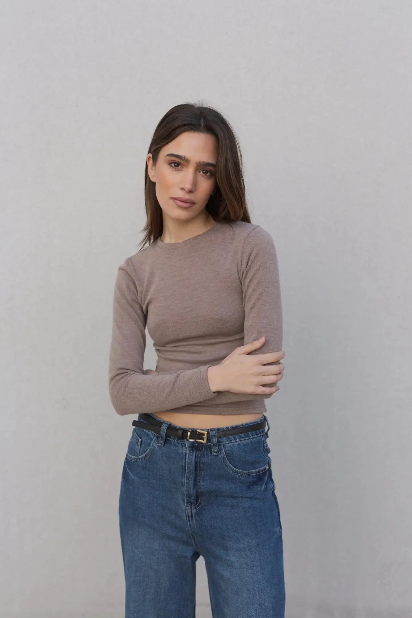 Femme portant un pull basique col rond à manches longues et jeans taille haute