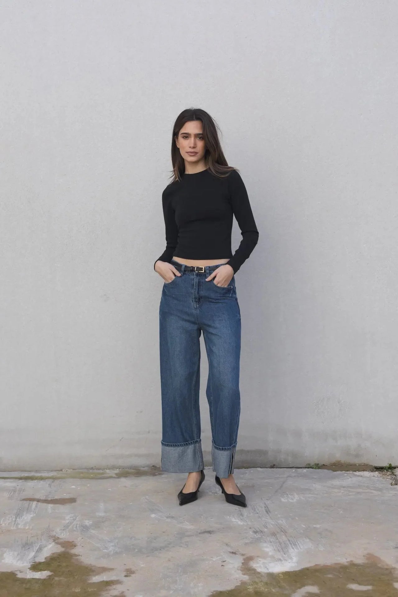 Pull ajusté femme col rond manches longues en polyester et viscose - Noir et Beige, modèle féminin en pull noir ajusté avec jeans bleu.