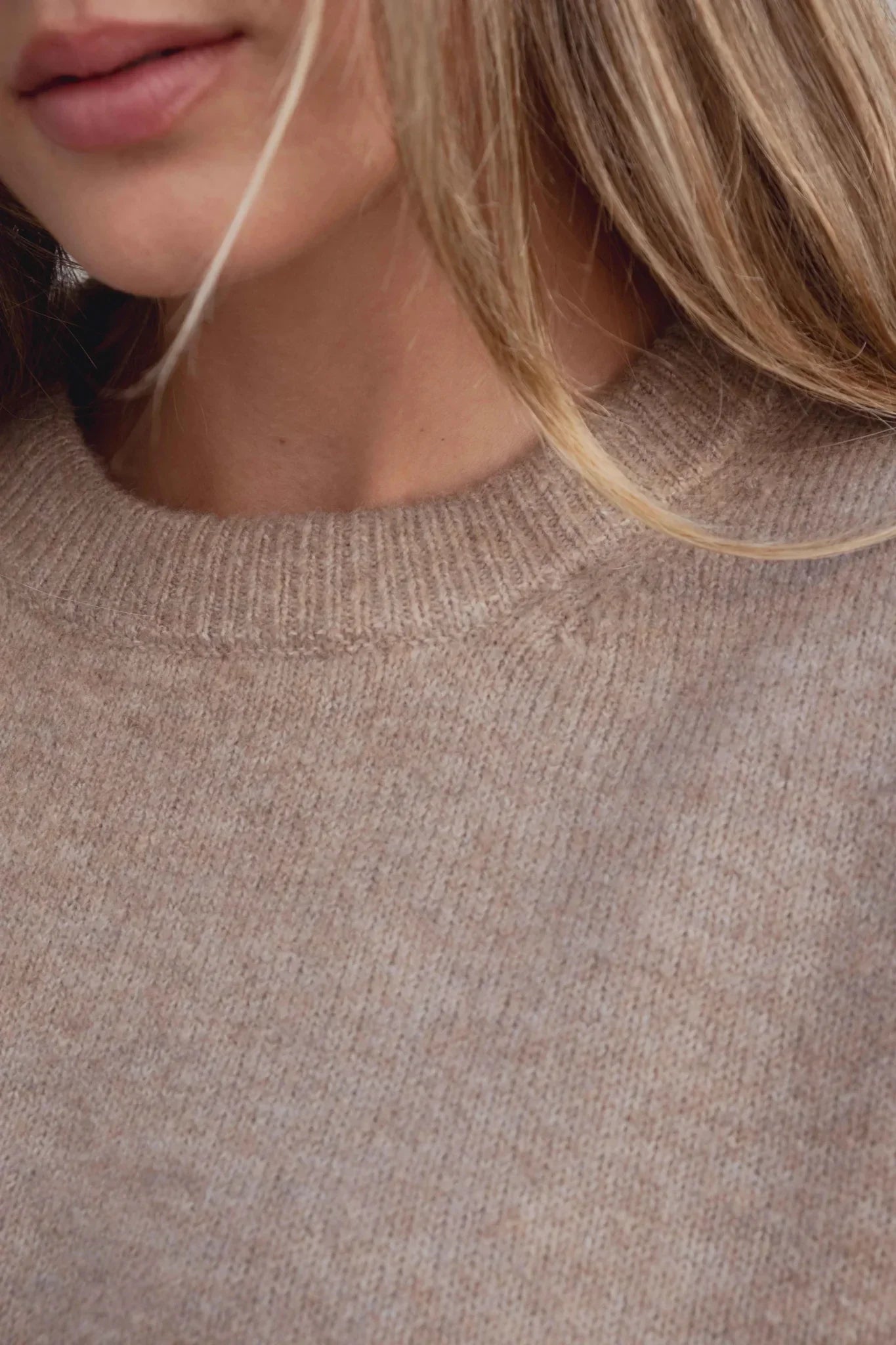 Femme portant un pull basique col rond en molleton beige clair pour un look décontracté