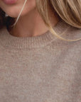 Gros plan sur le pull laine femme col rond marron, mettant en avant la douceur de la matière.