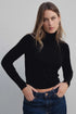 Modèle portant un pull col roulé noir en maille fine femme, parfait pour un look chic et moderne.