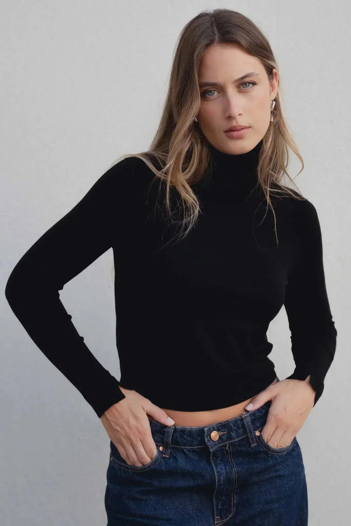 Modèle portant un pull col roulé noir en maille fine femme, parfait pour un look chic et moderne.