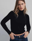 Modèle portant un pull col roulé noir en maille fine femme, parfait pour un look chic et moderne.
