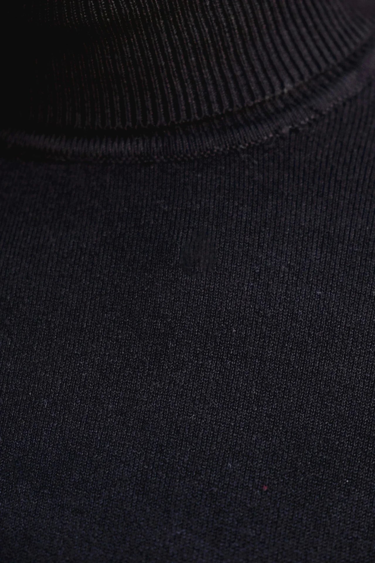 Zoom sur le col du pull col roulé noir femme, mettant en avant la matière douce et extensible.