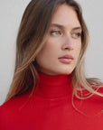 Détail sur le visage d'un modèle avec pull col roulé femme rouge, mettant en valeur le col roulé et un look chic.