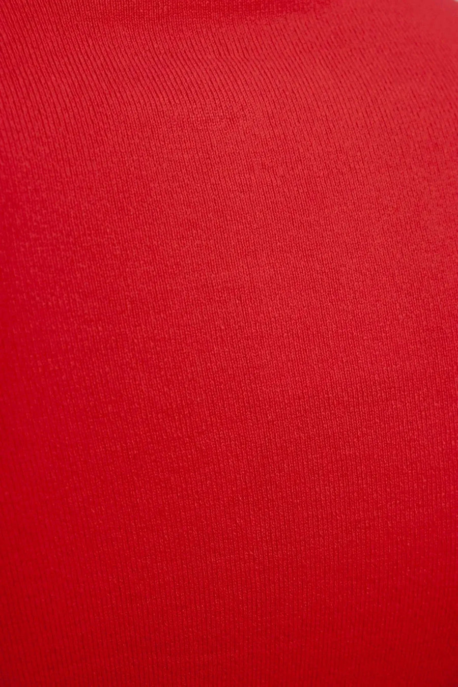 Zoom sur le tissu d'un pull col roulé femme rouge, illustrant la maille fine et la texture douce.