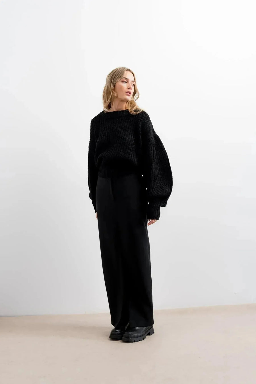 Pull Laine Femme Oversize à Manches Ballon - Femme en pull laine femme noir, se tenant debout, style élégant.