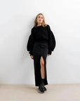 Pull Laine Femme Oversize à Manches Ballon - Femme avec un pull laine femme noir, look chic avec une jupe.