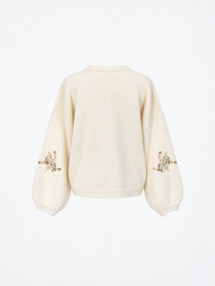 Pull en maille à perles et manches amples écru présenté de dos.