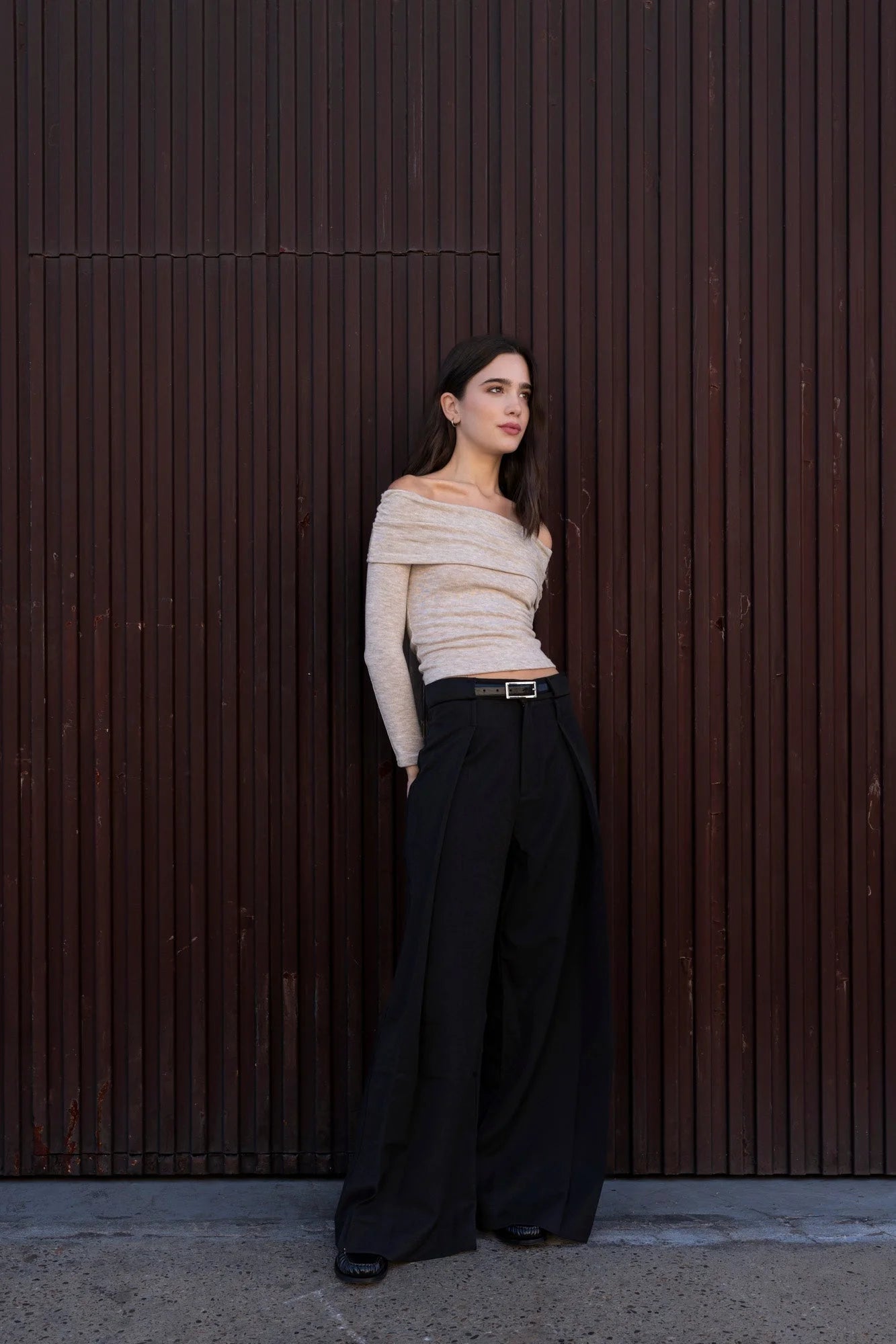 Femme portant un pull épaules dénudées beige, style chic et tendance