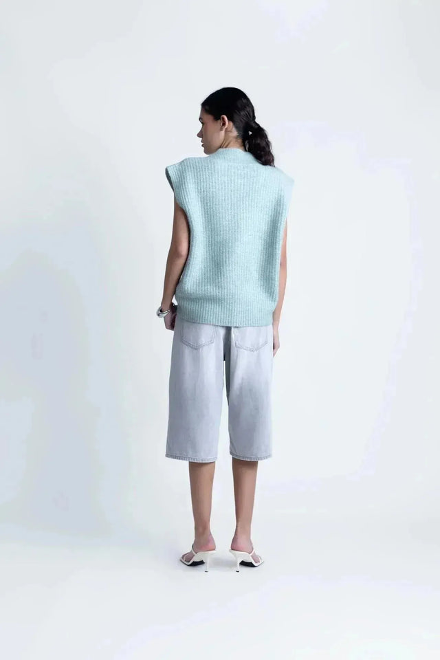 Vue arrière d'un pull sans manche femme oversize en tricot col V doux, mettant en avant sa coupe ample et confortable.