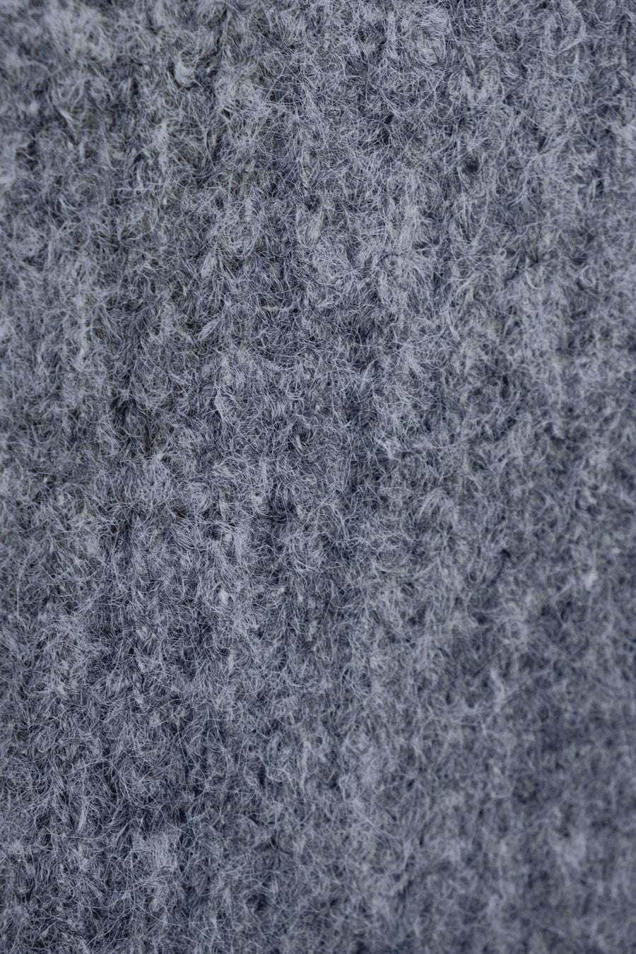 Zoom sur la texture du pull maille oversize gris, montrant le tricot côtelé et la douceur du tissu.