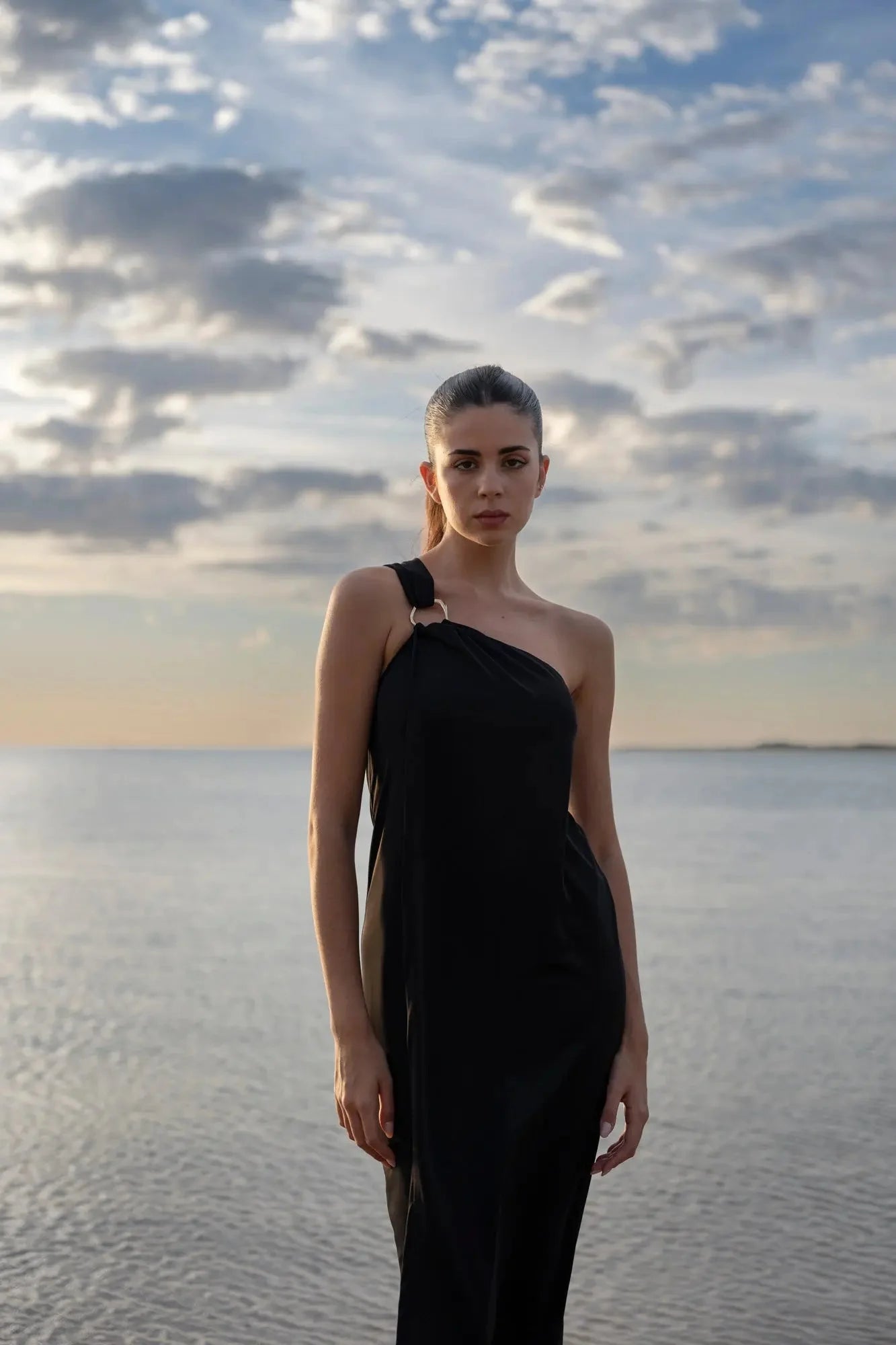 Robe asymétrique bijou noire avec détail anneau doré, idéale pour occasions spéciales