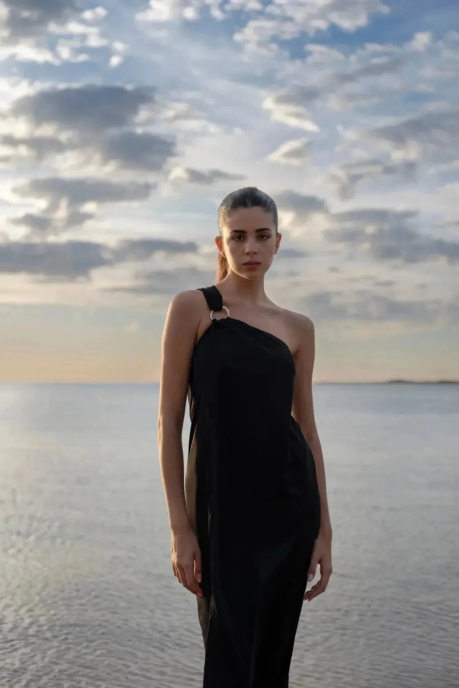 Robe asymétrique bijou noire avec détail anneau doré, idéale pour occasions spéciales