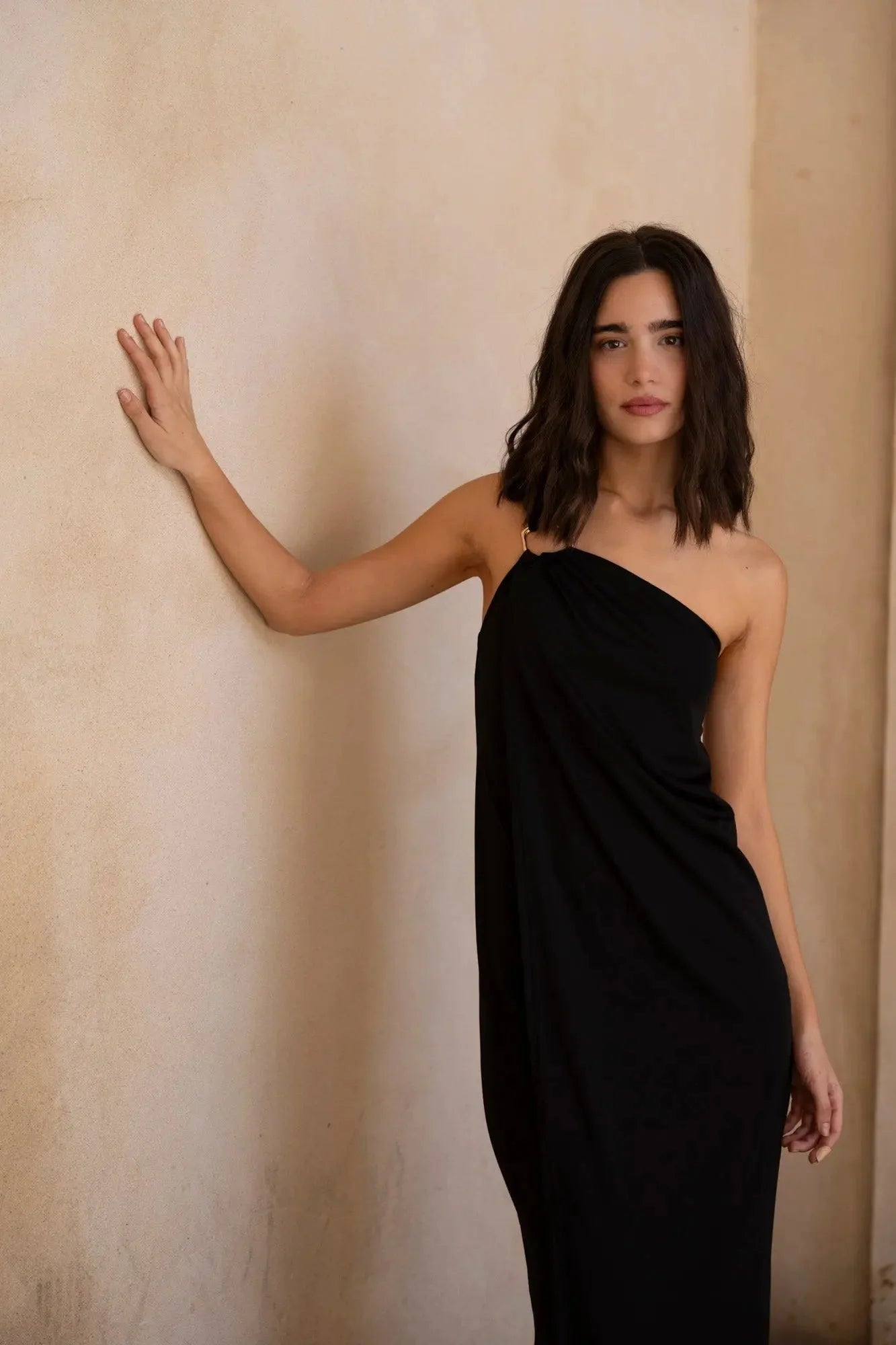 Femme portant la robe asymétrique bijou noire pour occasions spéciales