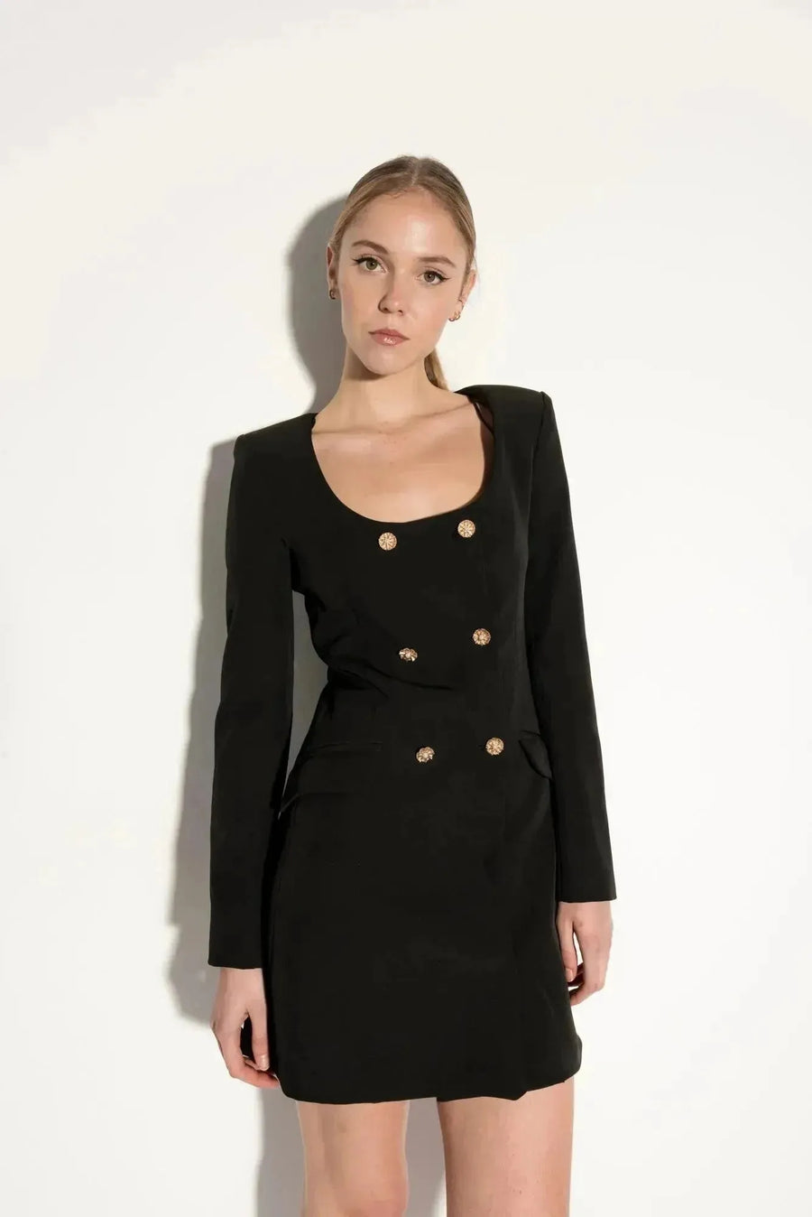 La Robe Blazer Noire à Boutons Dorés présente une coupe élégante et moderne, parfaite pour ajouter du chic à vos soirées et réunions. Idéale pour les femmes à la recherche d'une pièce sophistiquée, cette robe blazer souligne la silhouette avec style.