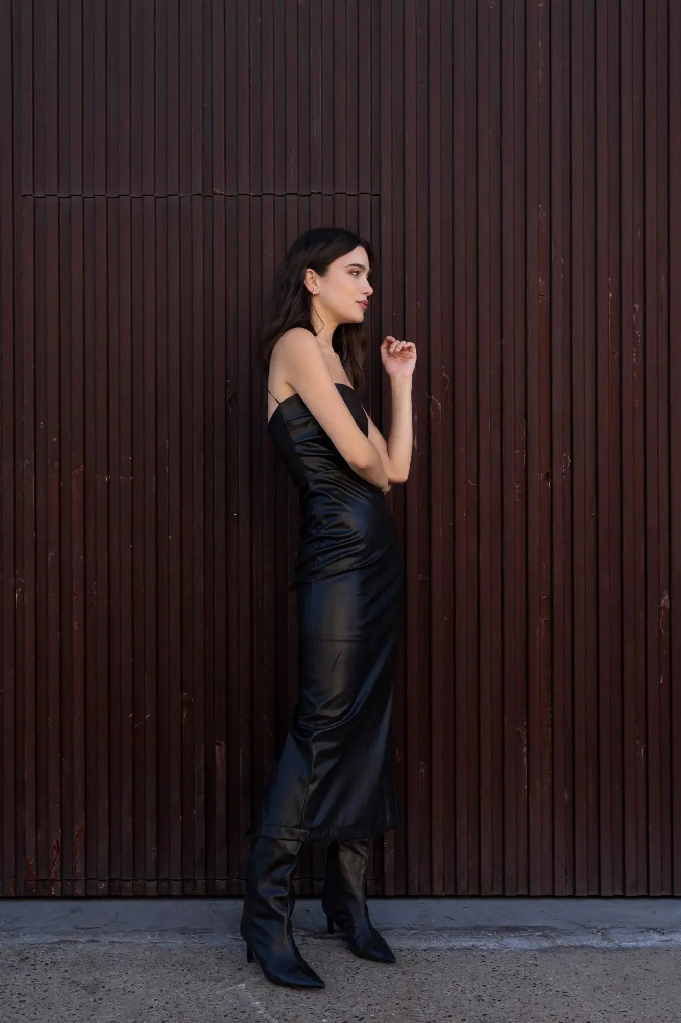 Robe bustier noire effet cuir midi avec fente latérale et bottes noires élégantes