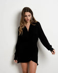 Modèle dans une Mini-Robe Portefeuille Chemise Courte Noire Asymétrique - Élégance Chic et Structurée. Robe portefeuille noire chic, col structuré et style moderne.