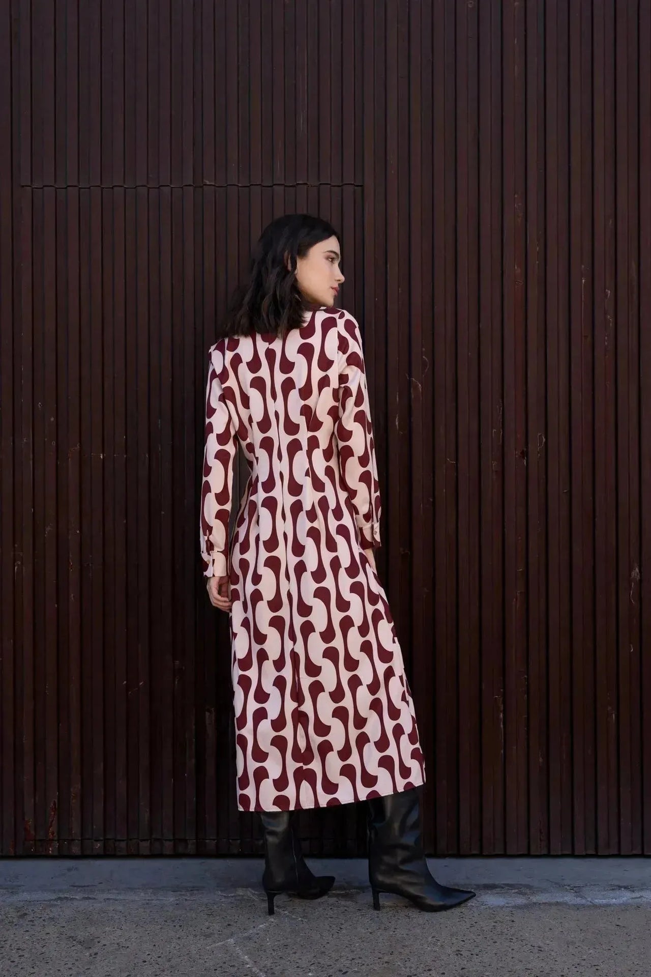 Vue arrière d'une femme en robe chemise longue imprimée bordeaux, montrant le design élégant et la coupe fluide.